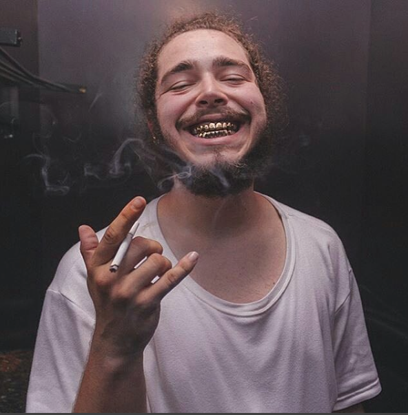 Post Malone raucht einer Zigarette (oder Cannabis)
